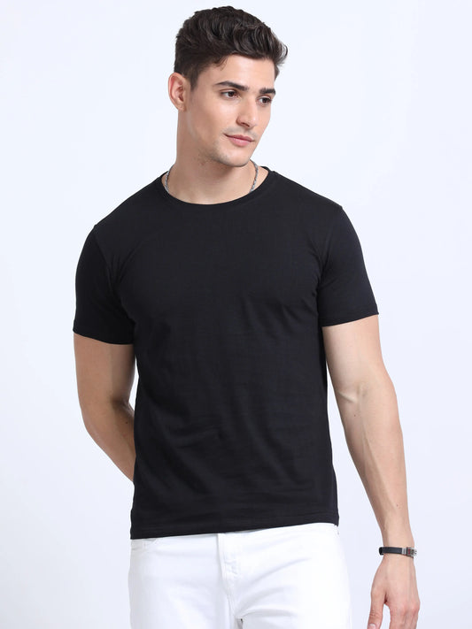 Man wearing plain black crew neck t-shirt and white pants, promotional apparel photography