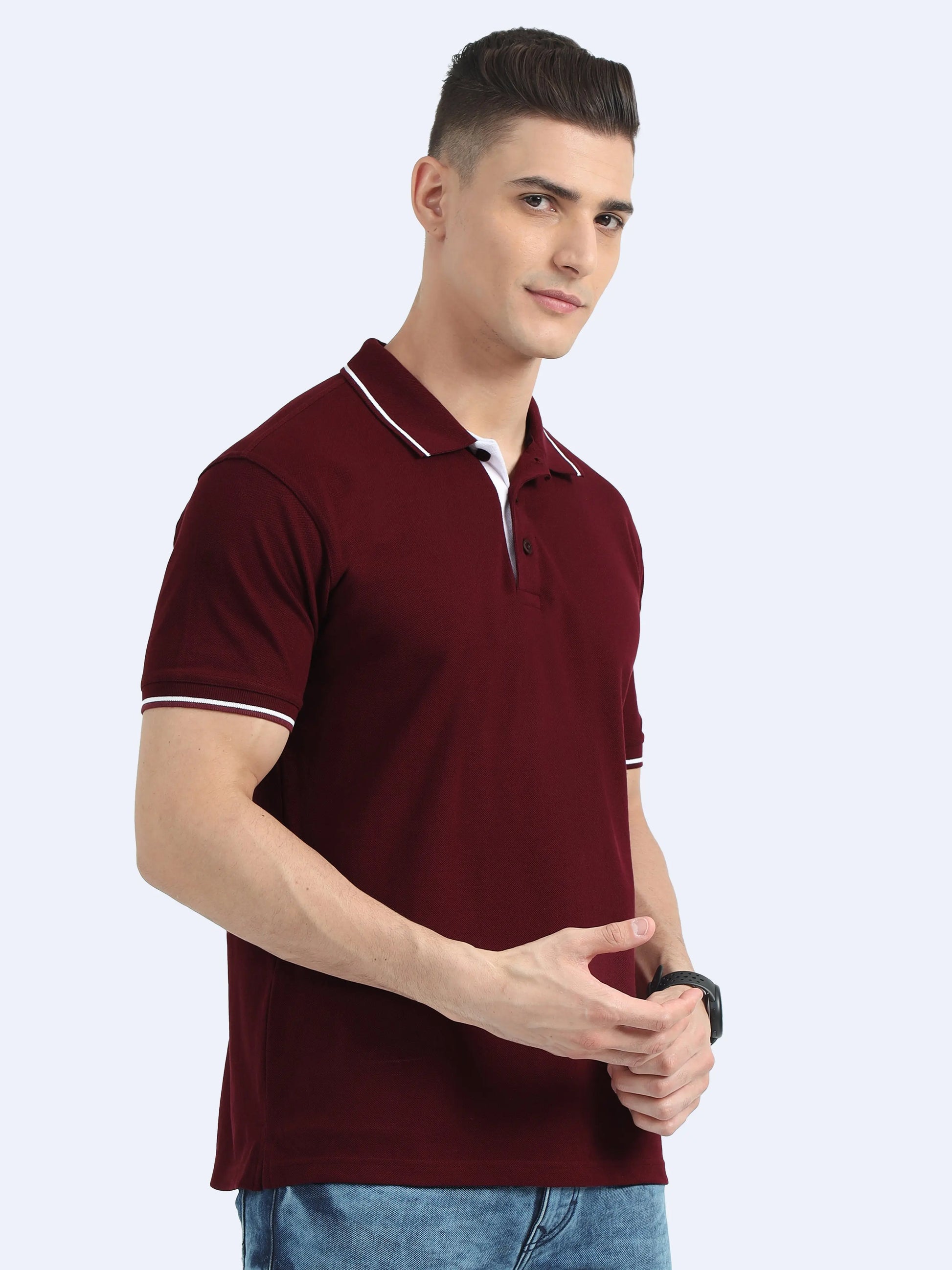 Man in maroon polo shirt with white trim, blue jeans, posing for apparel product photo