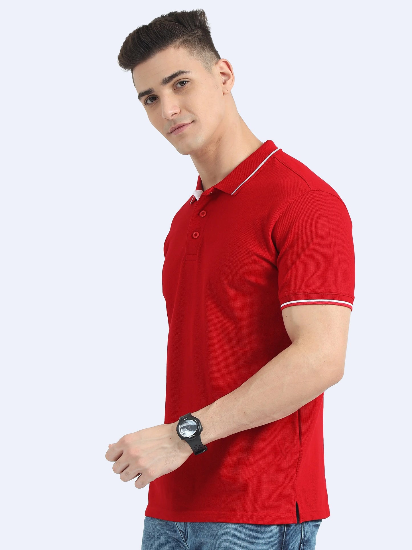 Man wearing red polo t-shirt with white trim, blue jeans, and black wristwatch