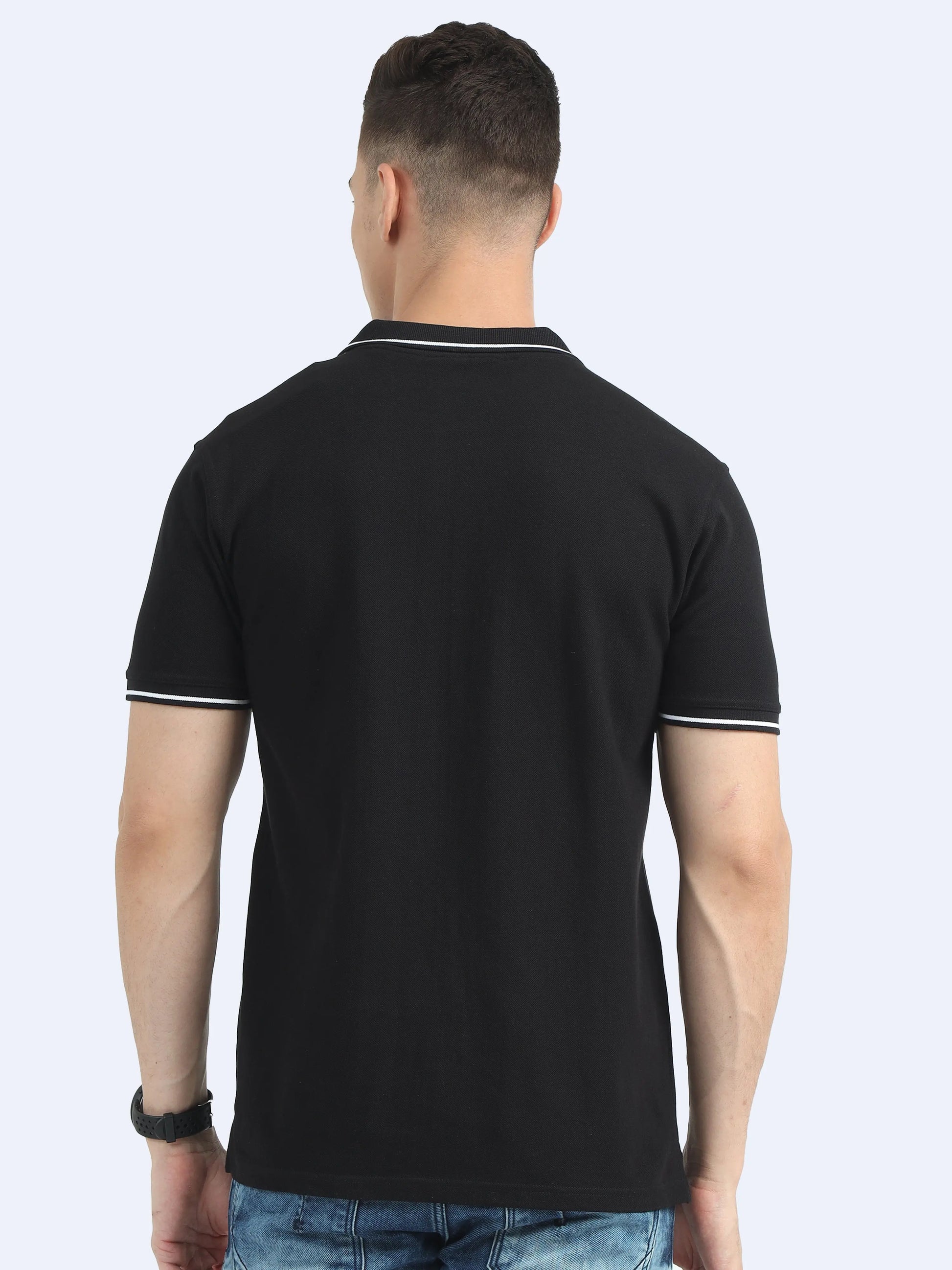 Back view of man wearing black polo t-shirt with white trim, casual corporate apparel