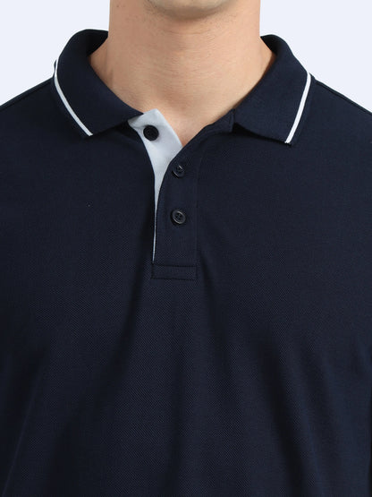 Close-up of a navy blue polo shirt with white collar trim and button placket, ideal for corporate uniforms.