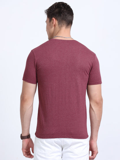 Back view of a man wearing a maroon short-sleeve t-shirt and white pants