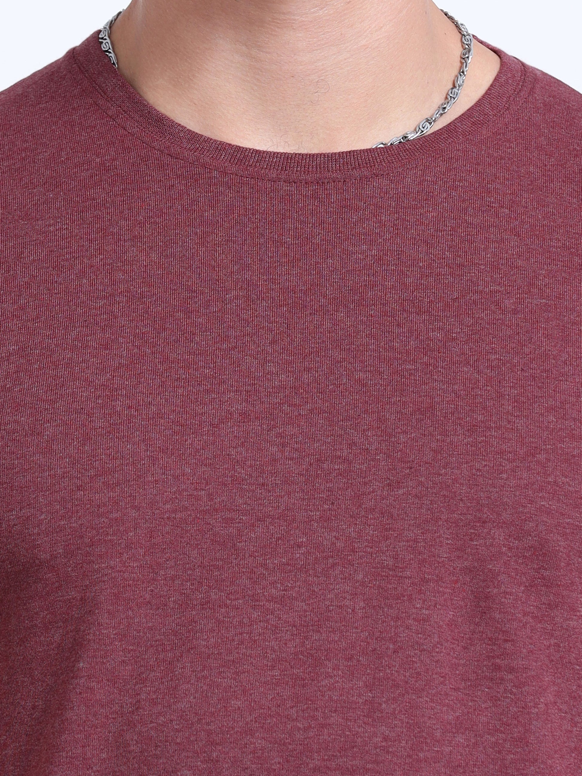Closeup of a maroon crew neck t-shirt worn by a person with a silver chain necklace