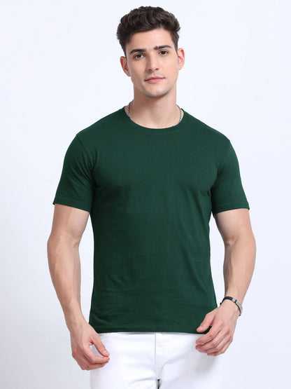 Man wearing plain green crew neck t-shirt and white pants, bulk team apparel