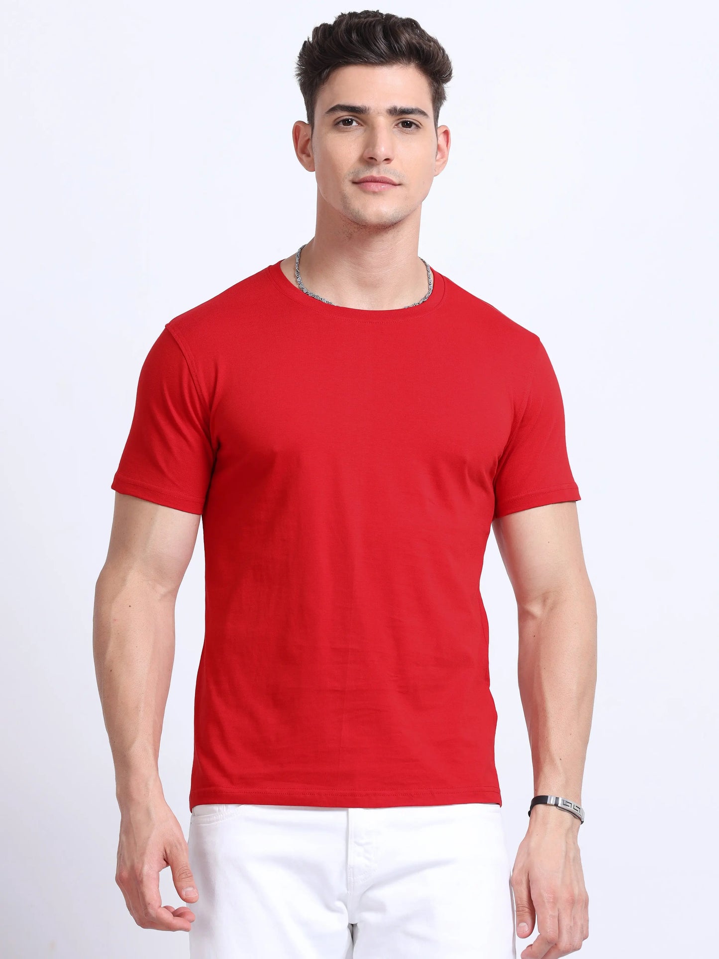 Man wearing plain red crew neck t-shirt and white pants, front view, studio background